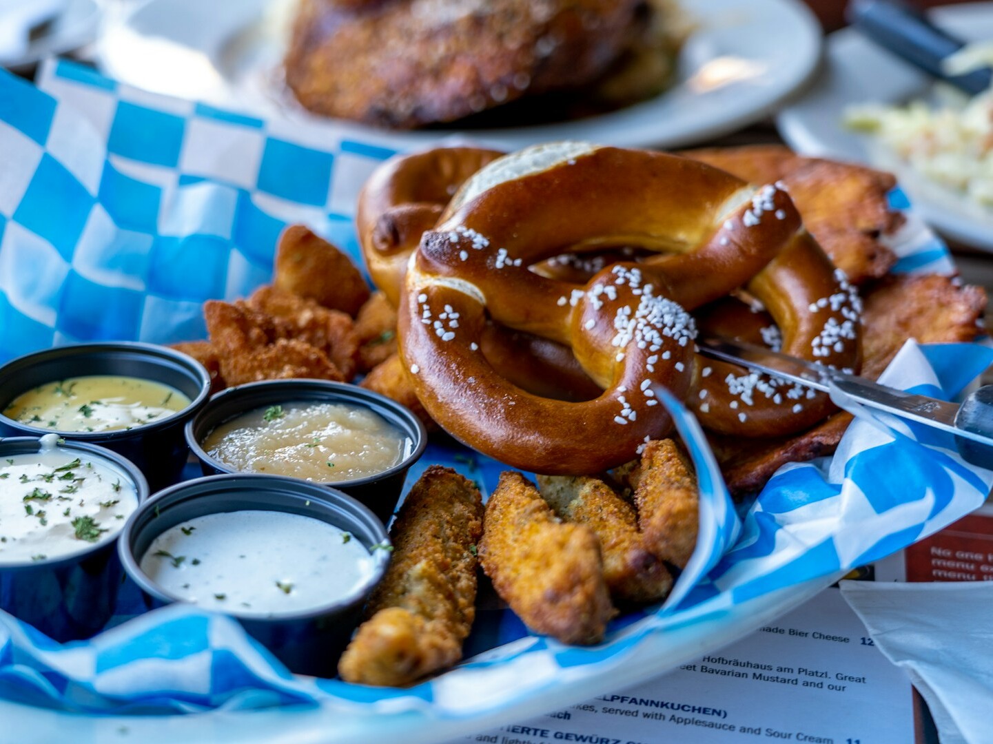 Brezel Ein Teller mit Essen, Saucen und Brezeln.